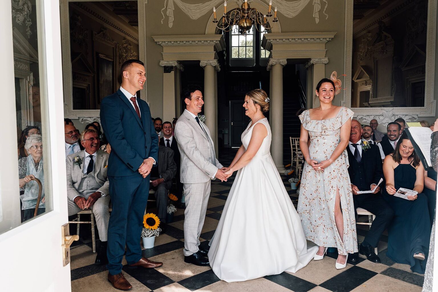 Wedding ceremony at Crowcombe Court with witnesses and family and friends watching the exchange of rings